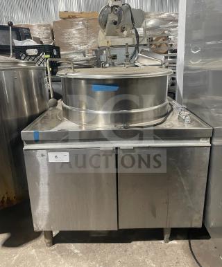 Stainless steel steam kettle with power tilt on sturdy legs, commercial-grade construction, moderate wear, labeled "6 Qty."