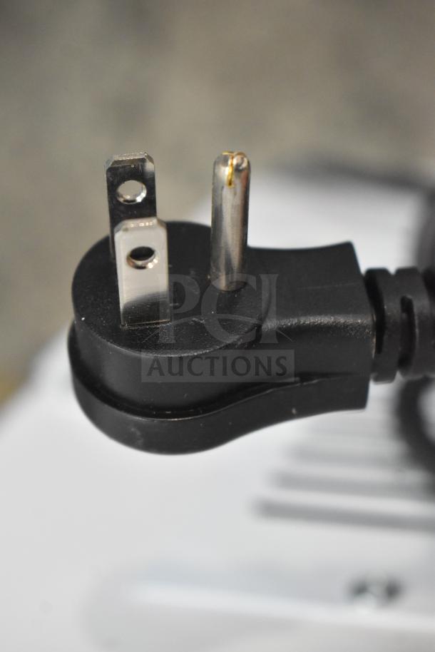 Close-up of a power plug for the Avantco 178CPW47HC ice cream dipping cabinet, showing a three-prong design.