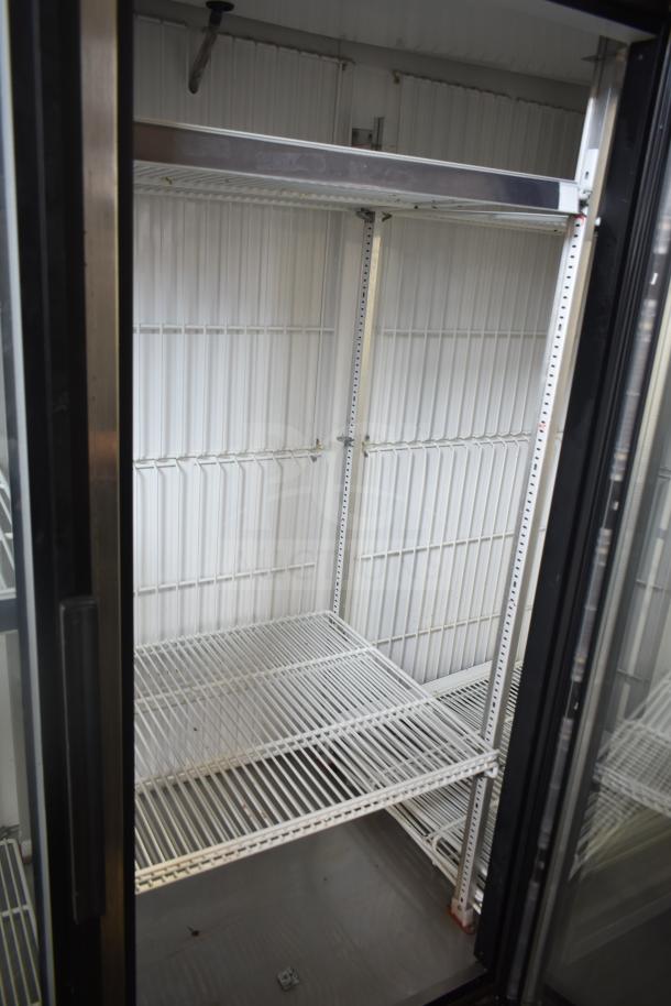 True GDM-72F-LD Commercial 3 Door Reach-In Freezer Merchandiser, shelves visible, good condition.