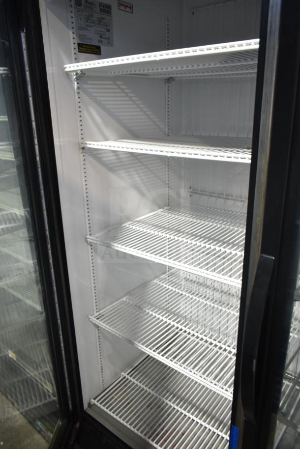 2018 True GDM-72F-LD commercial freezer, three doors, visible shelving, labels indicating voltage and model.
