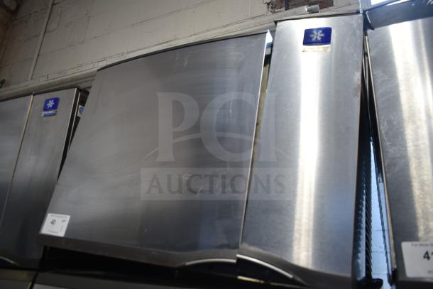 Manitowoc commercial ice machine head on hotel dispenser, stainless steel, 115 volts, 1 phase; visible brand logo.