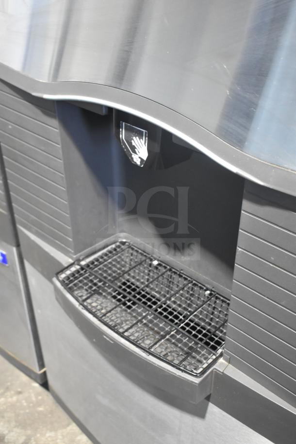 Manitowoc Commercial Ice Machine Head on Hotel Ice Dispenser, 115V, 1 Phase, black and silver, dispensing area visible.