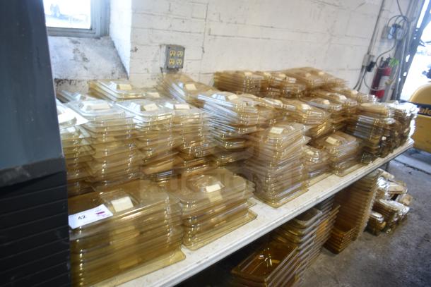 Stacked amber-colored drop-in bin lids on a tabletop, including models FG202P22AMBR, FG221P86AMBR; excellent condition.