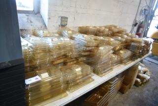 Stacked amber-colored drop-in bin lids on a tabletop, including models FG202P22AMBR, FG221P86AMBR; excellent condition.