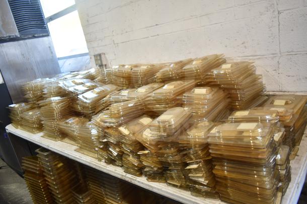 Tabletop lot of amber colored drop-in bin lids, including models FG202P22AMBR, FG221P86AMBR, stacked and in good condition.