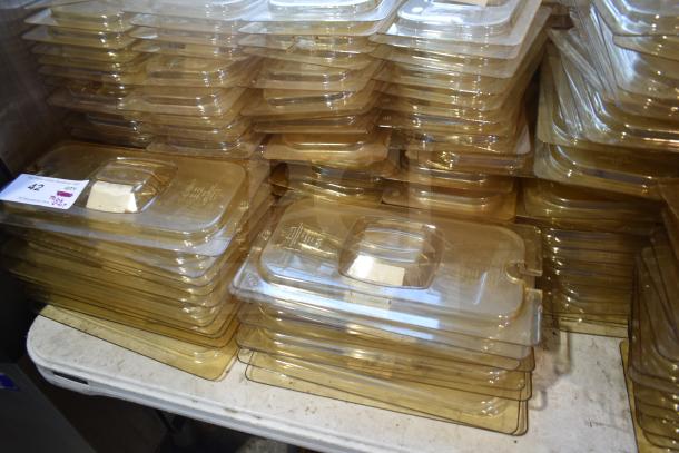 Stack of amber-colored drop-in bin lids, including models FG202P22AMBR and FG221P86AMBR, in good condition.