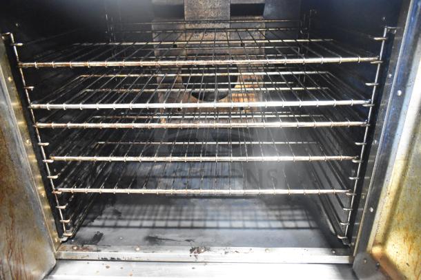 Royal commercial full-size convection oven interior with view-through door, wire racks, visible wear, on commercial casters.