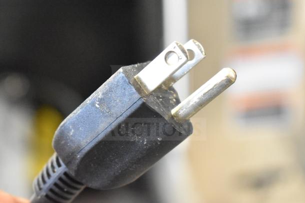 A close-up of a plug connected to the Transact MOD9700 DayMark 9700 Receipt Printer.