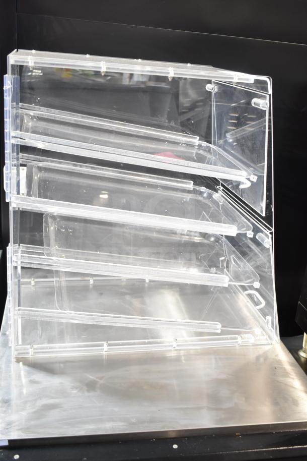 Clear Poly Dry Display Case Merchandiser, made of transparent polycarbonate, featuring multiple angled shelves for optimal product visibility.