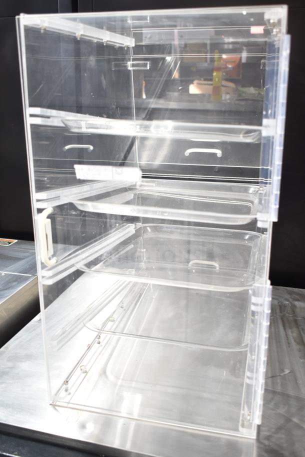 Clear poly dry display case merchandiser with three shelves, transparent design, and front handle; ideal for showcasing items.