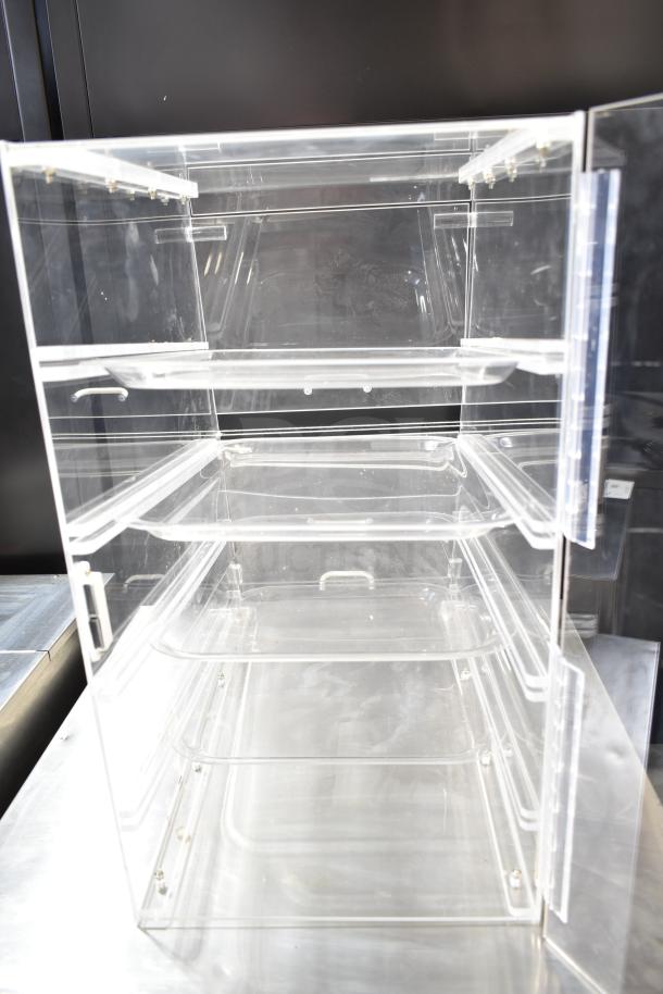 Clear Poly Dry Display Case Merchandiser with three shelves, transparent design, and hinged door. Good condition for showcasing items.