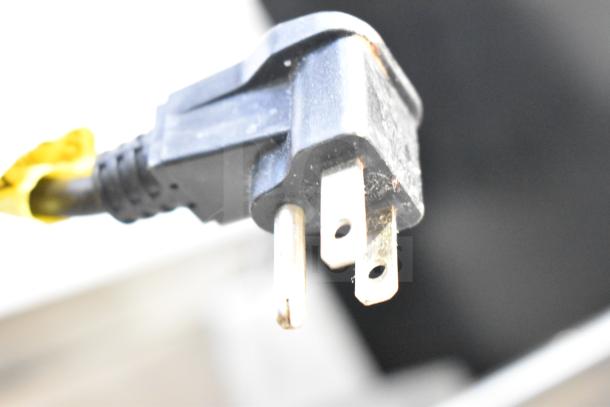 Close-up of a power plug for the Silver King SKR27AD/C11 commercial cooler, 115V, 1 Phase, black color, slightly worn.