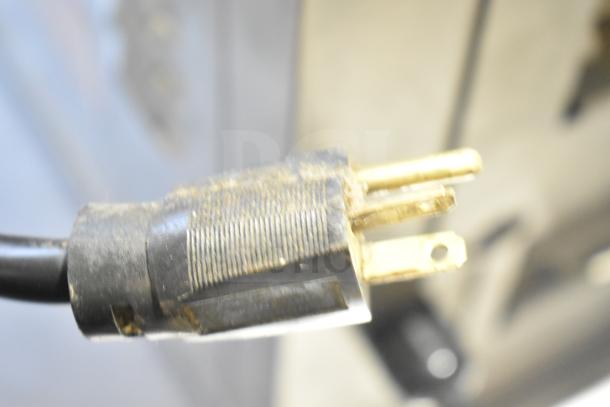 Close-up of a power plug for the Prince Castle DHB32F-DD Commercial Countertop Holding Bin, showing moderate wear.