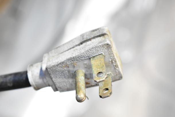 Close-up of a plug from a 2016 True TUC-27D-2-HC commercial cooler, showing signs of wear.