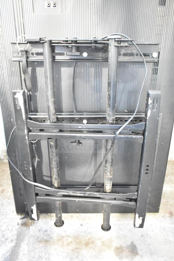 Two NEC V463 televisions with mounting brackets, showing back view and cables. Pick-up required, no shipping available.