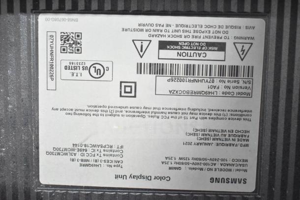 Label on the back of a Samsung display unit, detailing model code, version, and manufacturing information.