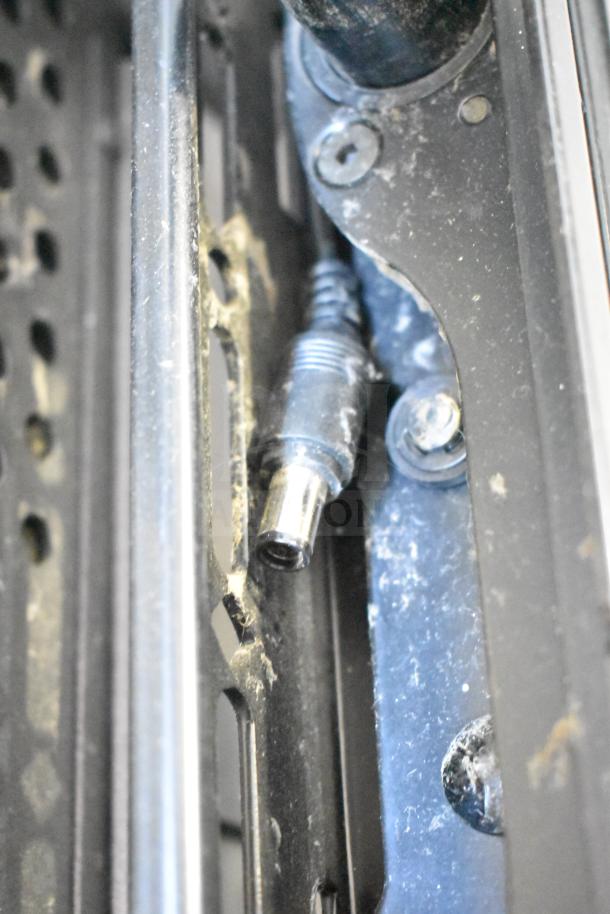 Close-up of a port on NEC V463 television showing moderate wear and dust, featuring a visible metallic connector.