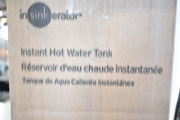 Brand new Insinkerator HWT-00 Instant Hot Water Tank with minor scratches and dents. Box shows multilingual product text.
