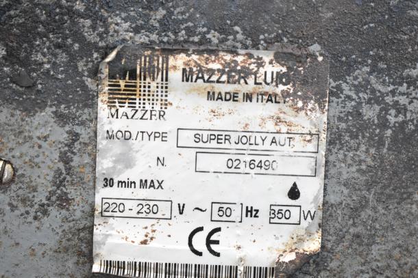 Mazzer Luigi Super Jolly Auto espresso grinder label, model info and voltage. Rust visible, worn condition.