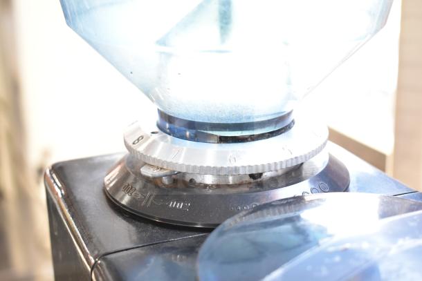 Commercial countertop espresso bean grinder, missing lid, with grind size dial. Operates on 120 volts, 1 phase.