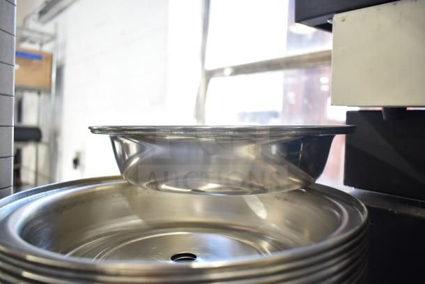 Stack of shiny metal dome covers, excellent condition, stacked in a commercial setting.