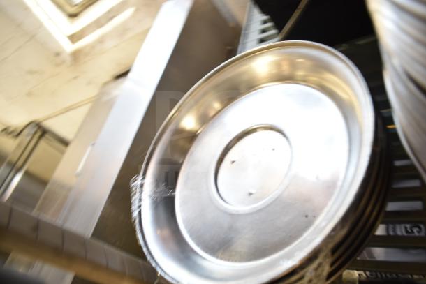 40 metal dome covers stacked, shiny finish, ideal for food service. Auction offers 40 times your bid, enhancing value.