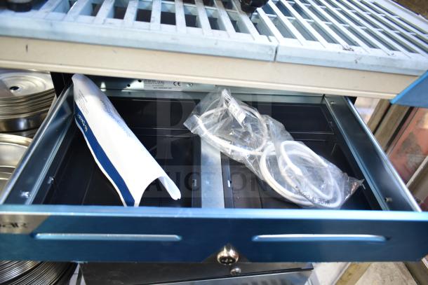 Five various cash drawers, metallic blue, open to reveal wiring and manual, appear in good condition.