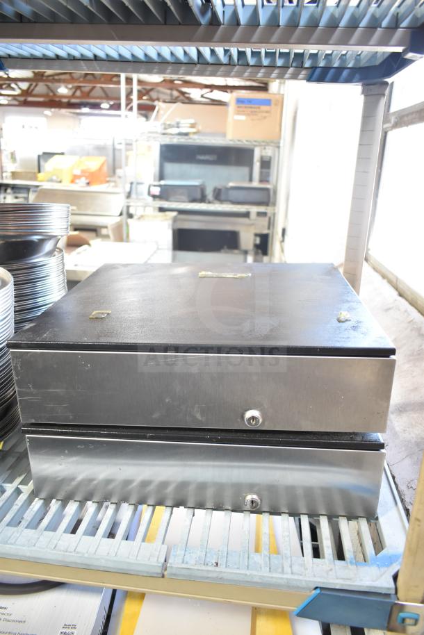 Five metal cash drawers with locks, stacked on shelving. Slight surface wear, ideal for retail use.