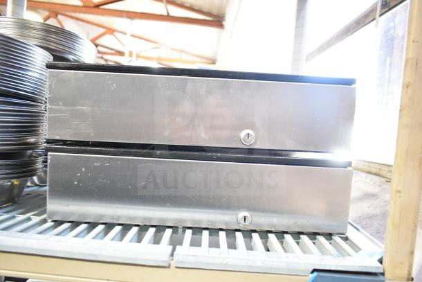 Five various silver cash drawers stacked on a shelf; each features a key lock. Auction item sold as five times your bid.
