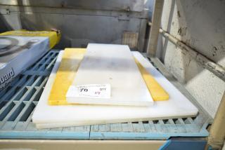 Four various cutting boards stacked, including white and yellow boards. Visible label: "70 QTY x4". Used condition.