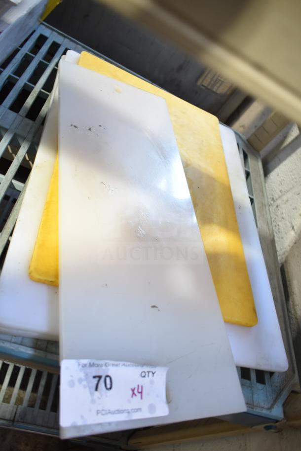 Four durable cutting boards, various sizes. White and yellow colors. Auction tag indicating quantity: 4. Good condition.