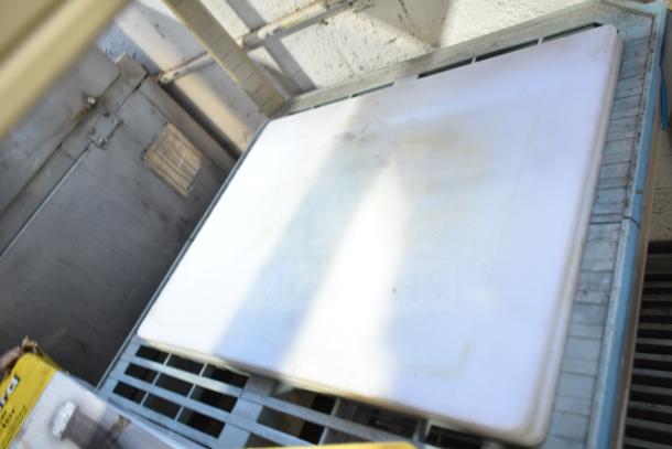 Four white cutting boards, slightly stained, various sizes, on a metal shelf. Ideal for kitchen prep. Good condition.