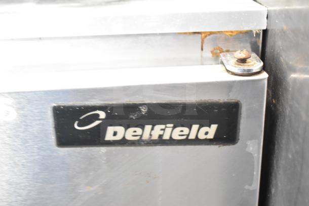 Delfield 406-CA undercounter cooler, single door, 115V, 1 phase. Visible wear on door edges and logo plate.