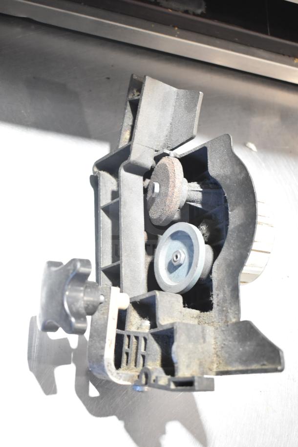 Bizerba Commercial Meat Slicer sharpener attachment, showing grinding stones and adjustment knob for maintenance.