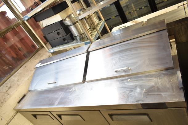 Atosa MSF8304 commercial prep table with stainless steel top, dual lids, and two doors. Includes commercial casters.