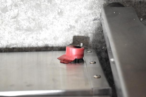 Stainless steel surface of a Cooking Performance Group 4 Burner Gas Range, model 351RCPG24NL, with protective red cap.