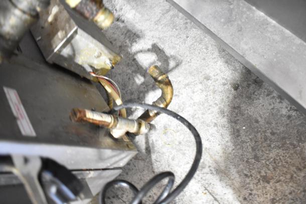 Natural gas connections and wiring for Hardt Inferno 4500 commercial rotisserie ovens, visible on industrial floor.