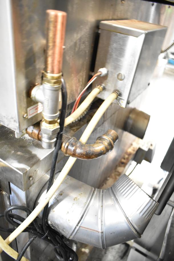 Two Hardt Inferno 4500 commercial gas rotisserie ovens on casters, 40 bird capacity, 95,000-101,000 BTU, pipes and wiring visible.