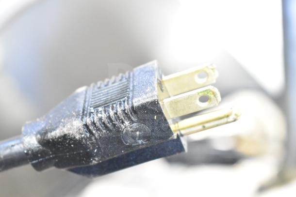 Close-up image of a plug for a 2021 Frontline 47SS Commercial Grease Caddy. Black casing, visible wear.