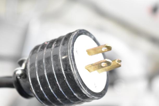 Cadco Unox XAF003 oven plug, black and gold, 120 volts compatible. Close-up emphasizing plug design and condition.