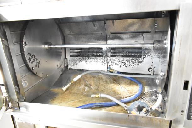 Hardt Inferno 4500 stainless steel commercial rotisserie oven interior, showing skewers and natural gas connections.