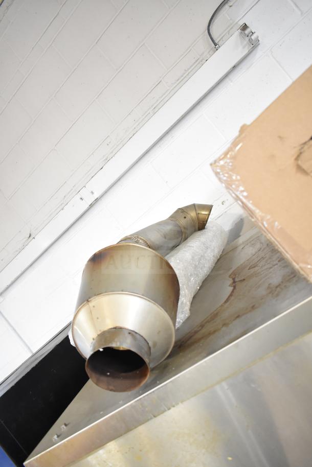 Hardt Inferno 4500 stainless steel rotisserie oven, showing skewers and metal legs on commercial casters, in used condition.