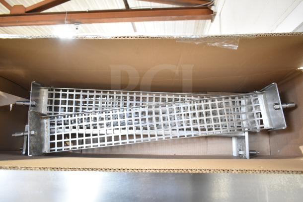 Hardt Inferno 4500 stainless steel rotisserie oven in box, includes skewers and metal legs on commercial casters.