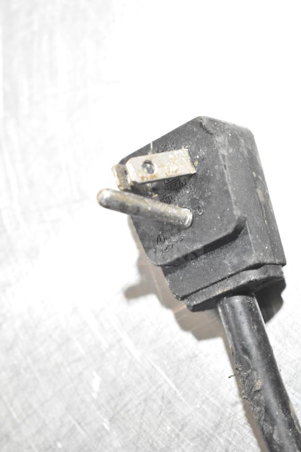 Close-up of a black electrical plug for the Everest Commercial 4 Drawer Cooler, showing three prongs and surface wear.
