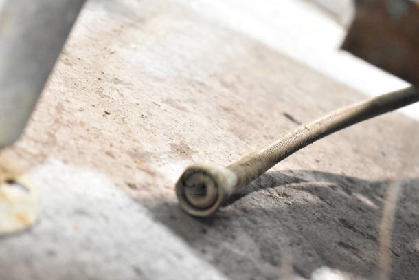 Close-up of a hose or metal cable connector on the floor, related to Cleveland 24EMK624 electric kettle. Condition unclear.