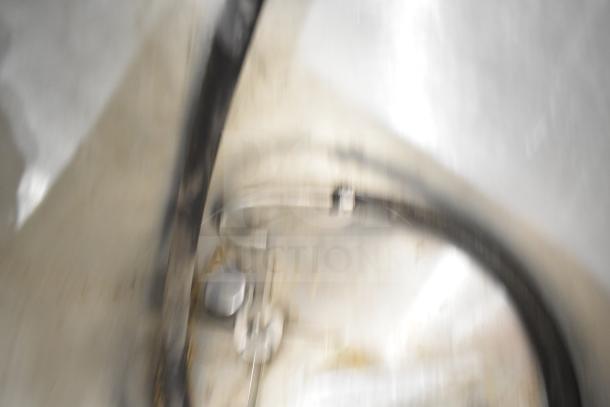 Oscar Fisher Stainless Steel Tank, blurred image showing metal construction, pipe fittings, and industrial features.