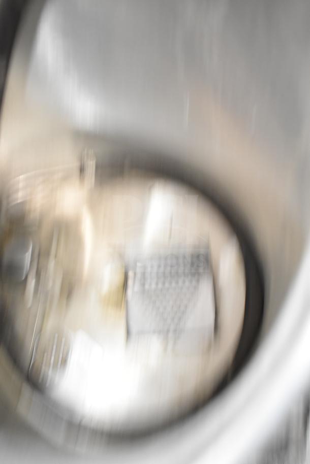 Blurry image of Oscar Fisher stainless steel tank interior; details indistinct.
