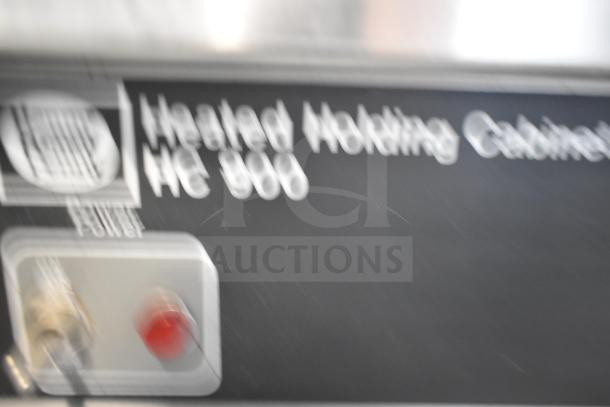 Henny Penny HC900 Heated Holding Cabinet, 115V, 1 Phase, on commercial casters. Blurry label displays model details.