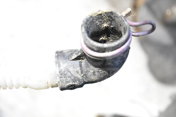 Close-up of a dishwasher drainage hose connection for Whirlpool WDT30HAMZ0. Shows the end with visible wear and grime.
