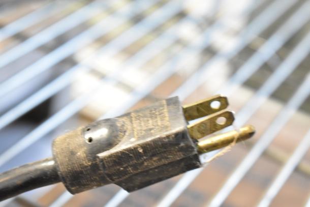 Roundup HDC-20 Countertop Hot Dog Corral plug, 120 Volts, 1 Phase, close-up, showing prongs and wear marks.